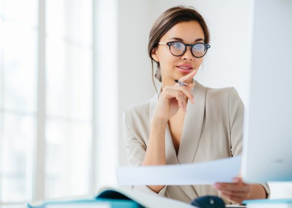 economist poses in coworking space, focused in monitor, verifies or checks figures